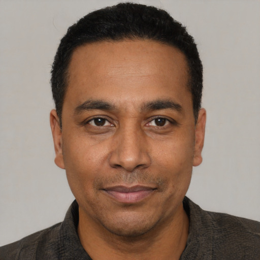 Joyful latino adult male with short  black hair and brown eyes