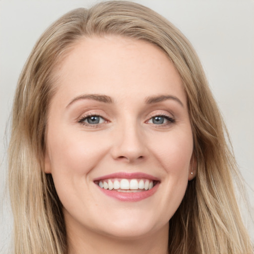 Joyful white young-adult female with long  brown hair and blue eyes