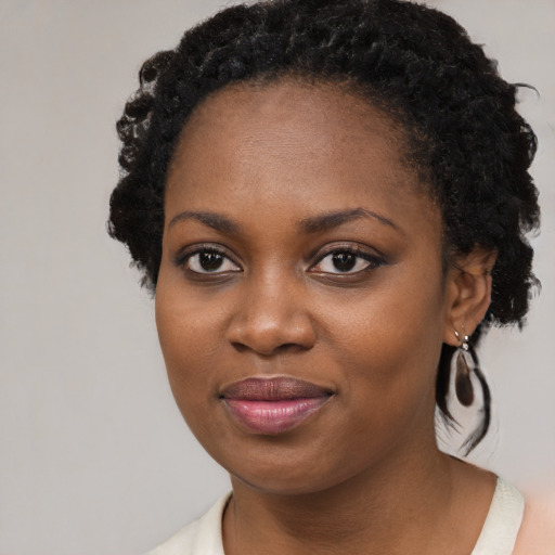 Joyful black young-adult female with long  black hair and brown eyes