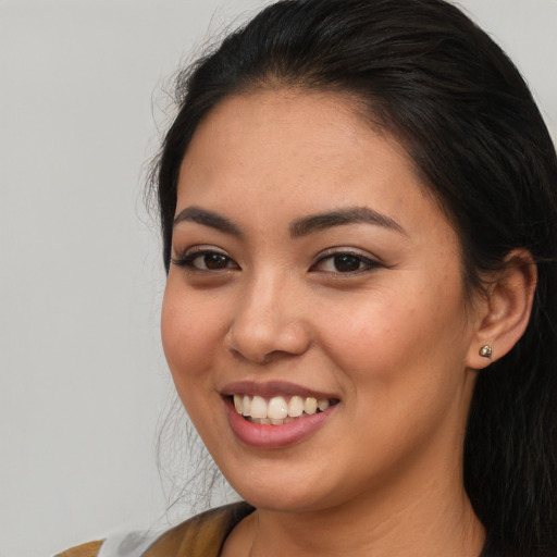 Joyful asian young-adult female with long  brown hair and brown eyes