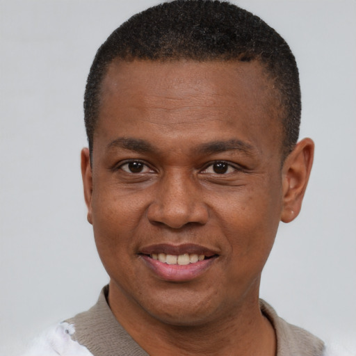 Joyful black adult male with short  brown hair and brown eyes