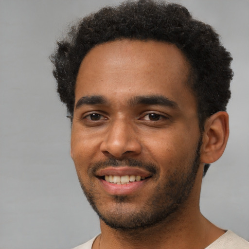 Joyful black young-adult male with short  black hair and brown eyes