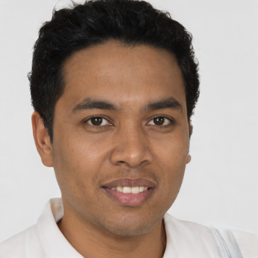 Joyful latino young-adult male with short  brown hair and brown eyes