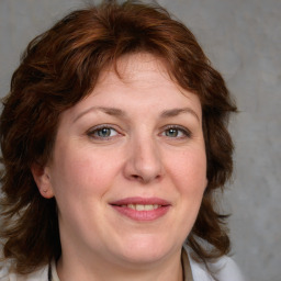 Joyful white adult female with medium  brown hair and blue eyes