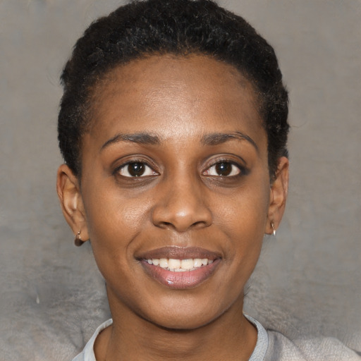 Joyful black young-adult female with short  black hair and brown eyes