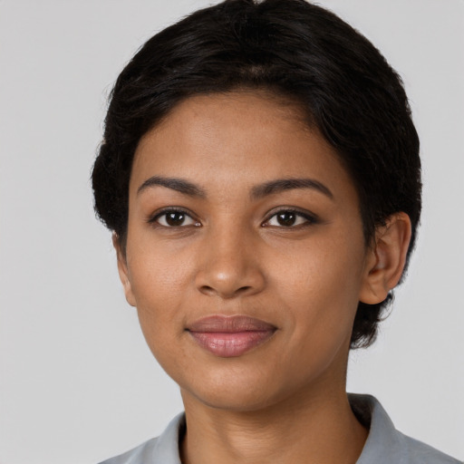 Joyful black young-adult female with short  black hair and brown eyes