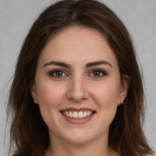 Joyful white young-adult female with long  brown hair and brown eyes