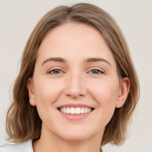 Joyful white young-adult female with medium  brown hair and green eyes