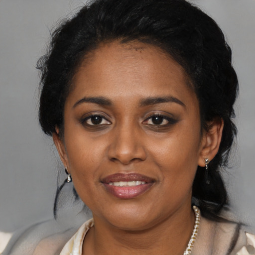 Joyful black young-adult female with medium  black hair and brown eyes
