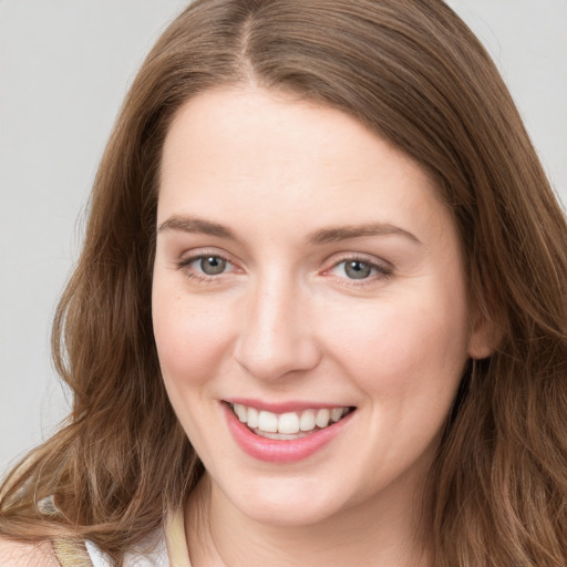 Joyful white young-adult female with long  brown hair and green eyes