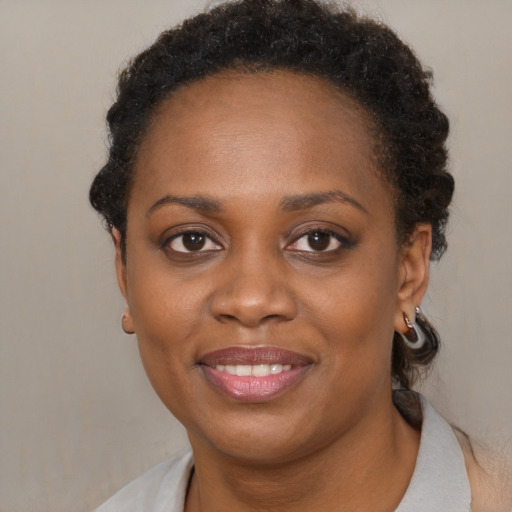 Joyful black young-adult female with short  brown hair and brown eyes