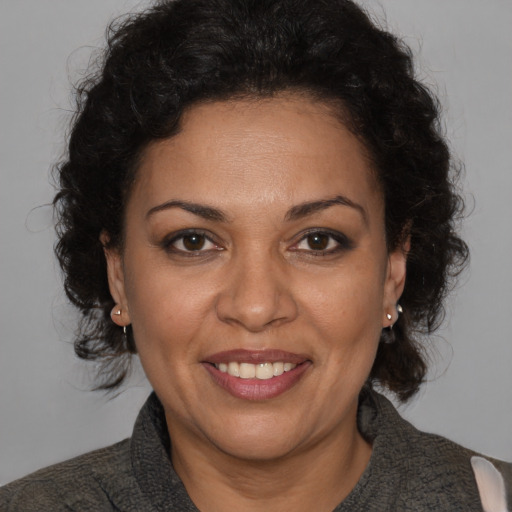 Joyful latino adult female with medium  brown hair and brown eyes