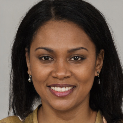 Joyful black young-adult female with long  brown hair and brown eyes