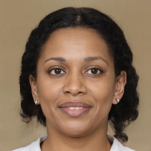 Joyful black adult female with medium  brown hair and brown eyes