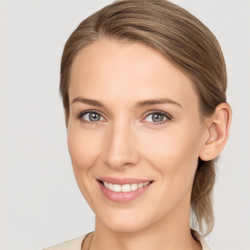 Joyful white young-adult female with medium  brown hair and grey eyes