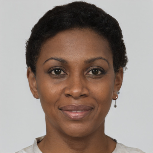 Joyful black young-adult female with short  black hair and brown eyes