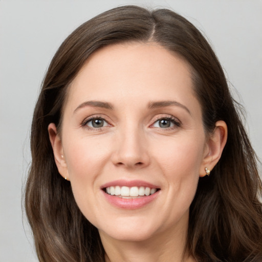 Joyful white young-adult female with long  brown hair and grey eyes