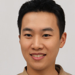 Joyful asian young-adult male with short  black hair and brown eyes