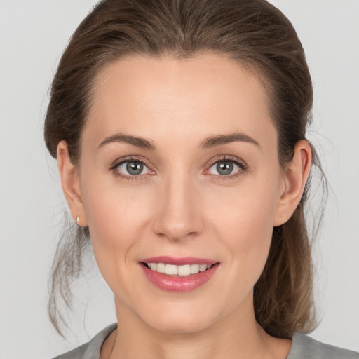 Joyful white young-adult female with medium  brown hair and grey eyes