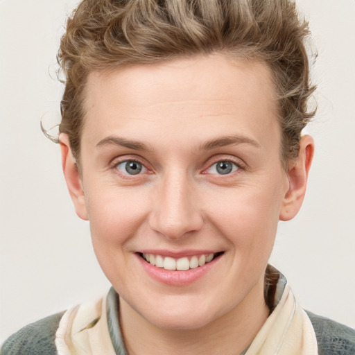 Joyful white young-adult female with short  brown hair and blue eyes