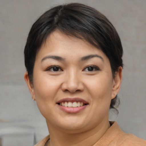 Joyful asian young-adult female with short  brown hair and brown eyes
