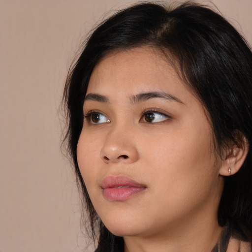 Joyful asian young-adult female with long  brown hair and brown eyes