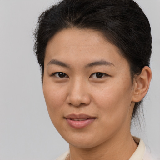Joyful asian young-adult female with short  brown hair and brown eyes