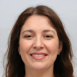 Joyful white adult female with long  brown hair and brown eyes