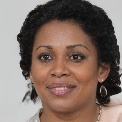 Joyful black adult female with medium  brown hair and brown eyes