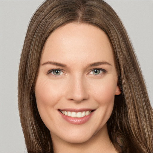 Joyful white young-adult female with long  brown hair and green eyes