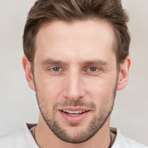 Joyful white young-adult male with short  brown hair and grey eyes