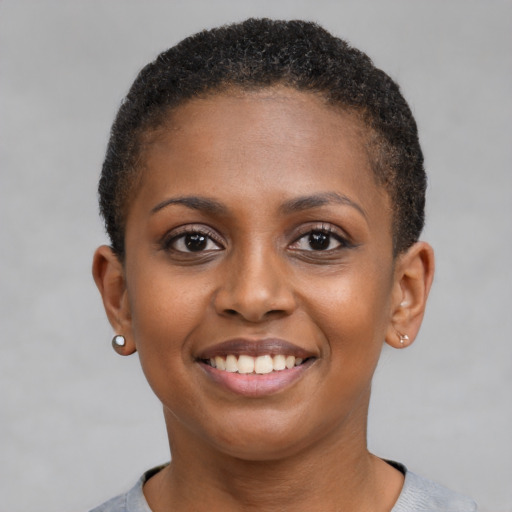 Joyful black young-adult female with short  brown hair and brown eyes
