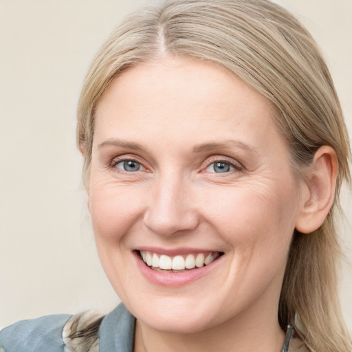 Joyful white young-adult female with medium  brown hair and blue eyes