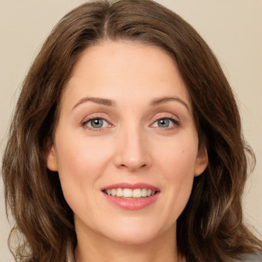 Joyful white young-adult female with long  brown hair and green eyes