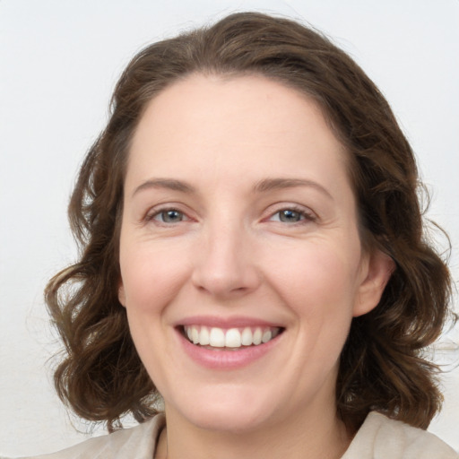 Joyful white young-adult female with medium  brown hair and grey eyes