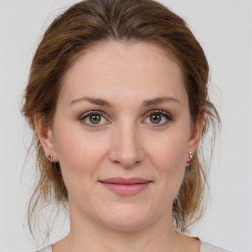 Joyful white young-adult female with medium  brown hair and green eyes