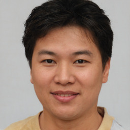 Joyful asian young-adult male with short  brown hair and brown eyes