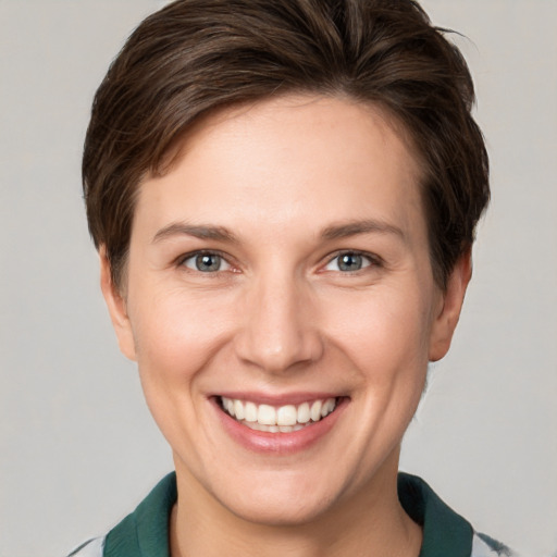 Joyful white young-adult female with short  brown hair and grey eyes