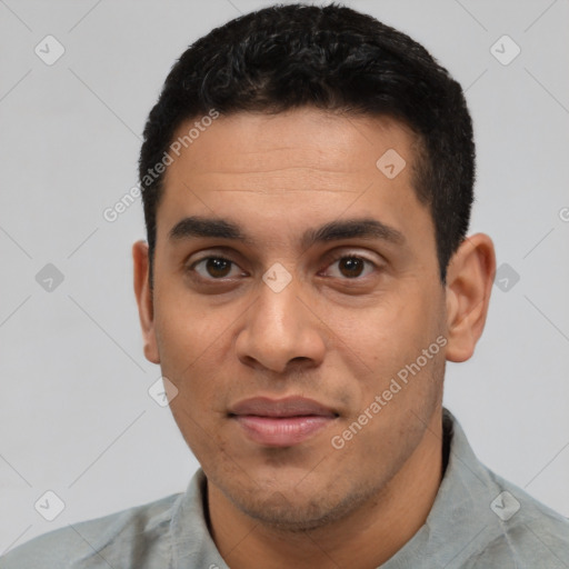 Joyful latino young-adult male with short  black hair and brown eyes