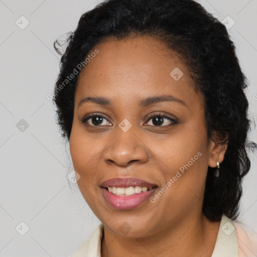 Joyful black young-adult female with long  brown hair and brown eyes