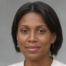 Joyful black adult female with medium  brown hair and brown eyes