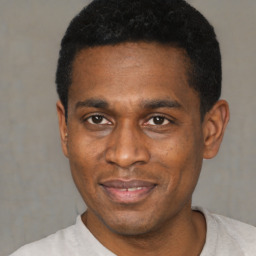 Joyful black adult male with short  black hair and brown eyes