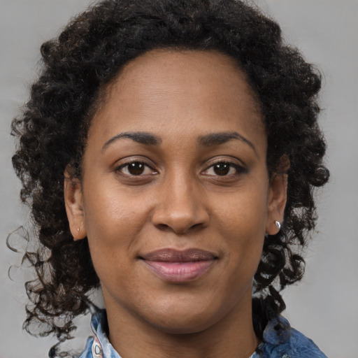 Joyful black adult female with long  brown hair and brown eyes