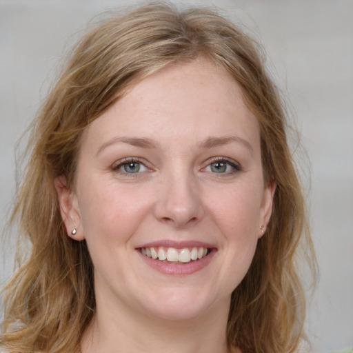 Joyful white young-adult female with medium  brown hair and blue eyes