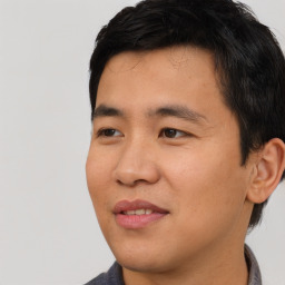 Joyful asian young-adult male with short  black hair and brown eyes