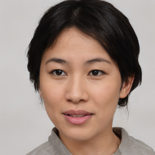 Joyful asian young-adult female with medium  black hair and brown eyes