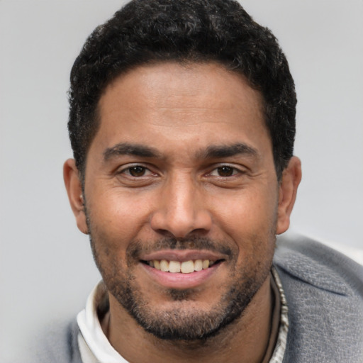 Joyful white young-adult male with short  black hair and brown eyes