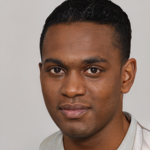 Joyful black young-adult male with short  brown hair and brown eyes