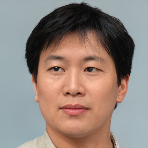 Joyful asian adult male with short  brown hair and brown eyes