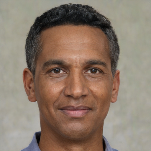 Joyful black adult male with short  black hair and brown eyes